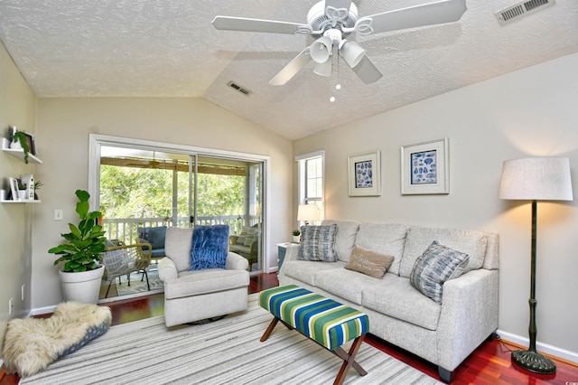 living room featuring hardwood / wood-style flooring, a textured ceiling, ceiling fan, and vaulted ceiling