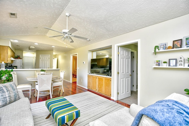 living room with lofted ceiling, a textured ceiling, hardwood / wood-style flooring, and ceiling fan