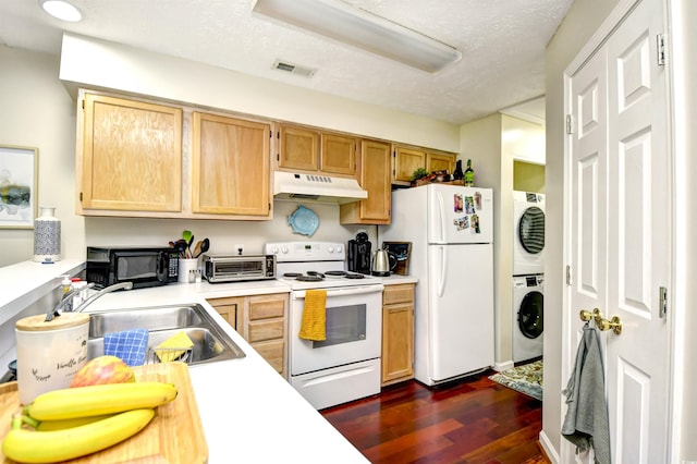 kitchen featuring white appliances, dark hardwood / wood-style floors, a textured ceiling, and stacked washing maching and dryer