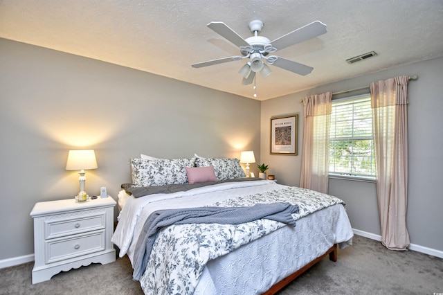 carpeted bedroom featuring a textured ceiling and ceiling fan