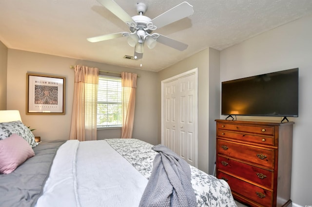 bedroom with ceiling fan, a textured ceiling, and a closet