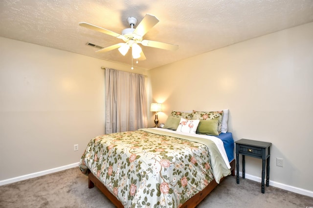 carpeted bedroom featuring a textured ceiling and ceiling fan