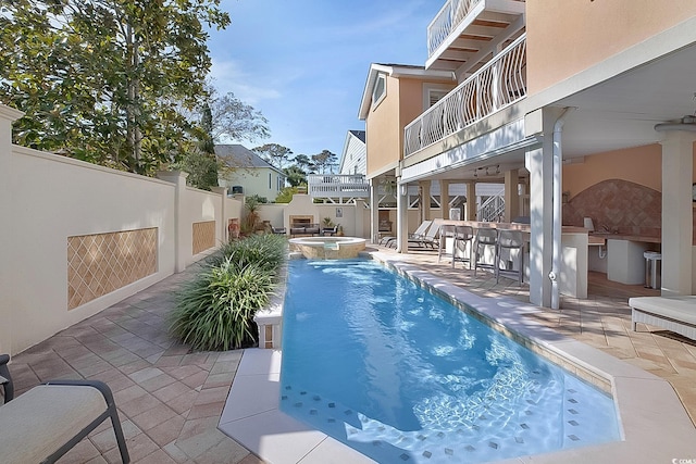 view of pool with a patio, a bar, area for grilling, and an in ground hot tub