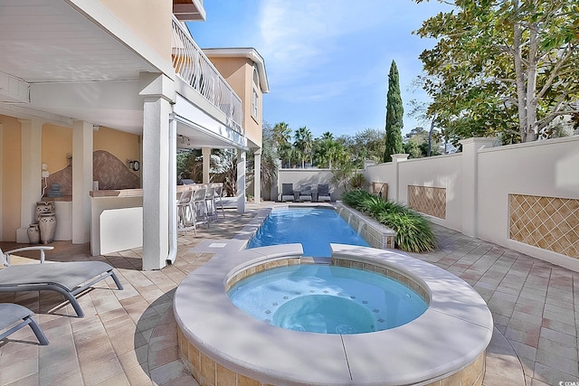 view of pool with a patio and an in ground hot tub