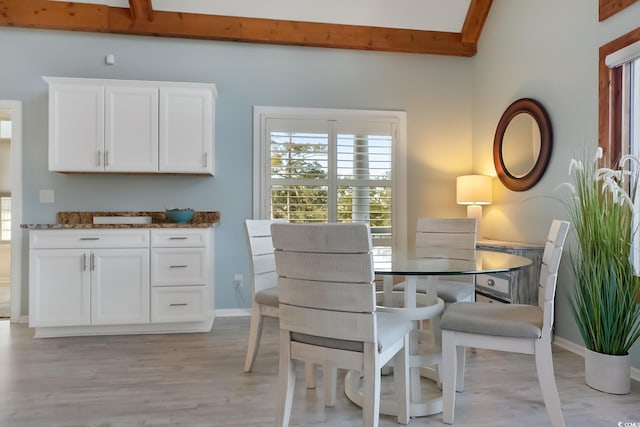 dining room featuring light hardwood / wood-style floors and beam ceiling