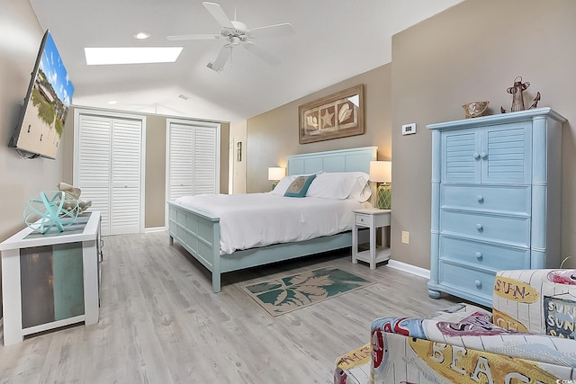 bedroom featuring light wood-type flooring, vaulted ceiling with skylight, and ceiling fan