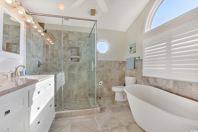 full bathroom with tile walls, separate shower and tub, vanity, toilet, and ceiling fan