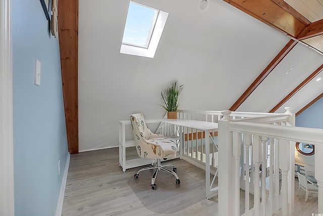 office area featuring light hardwood / wood-style floors and vaulted ceiling with skylight