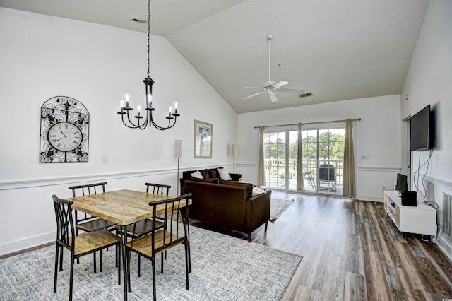 dining area with high vaulted ceiling, hardwood / wood-style floors, and ceiling fan with notable chandelier