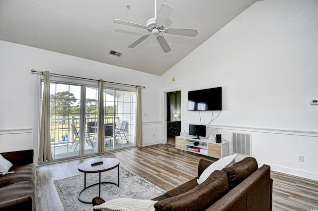 living room with high vaulted ceiling, hardwood / wood-style floors, ceiling fan, and a textured ceiling