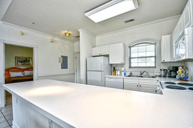 kitchen with white appliances, white cabinetry, a textured ceiling, and ornamental molding