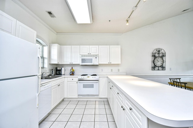 kitchen with kitchen peninsula, light tile patterned floors, white appliances, crown molding, and white cabinets