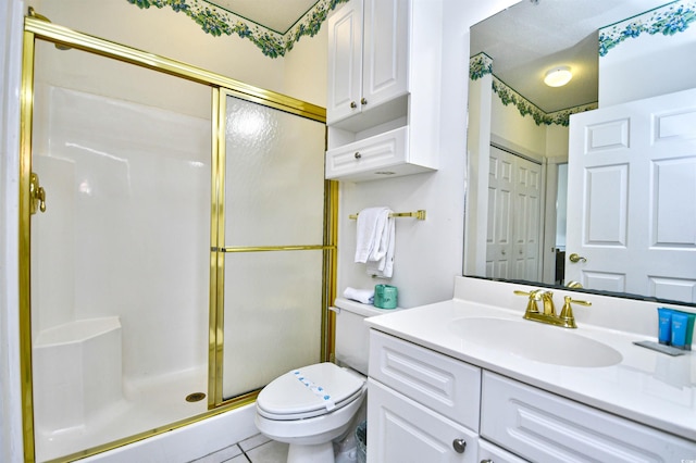 bathroom featuring vanity, a shower with door, tile patterned flooring, and toilet