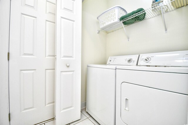 laundry room featuring light tile patterned floors and separate washer and dryer