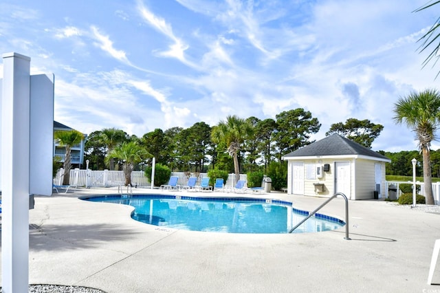 view of swimming pool featuring an outbuilding and a patio