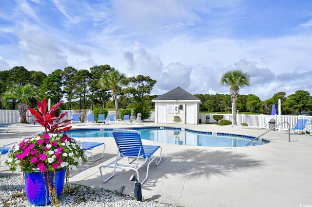 view of pool with an outbuilding and a patio