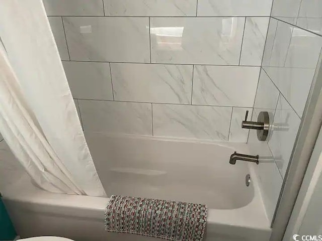 bathroom featuring shower / bath combo and toilet