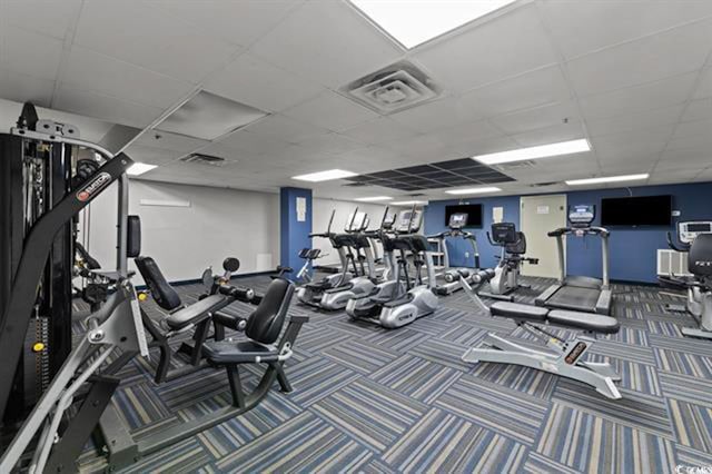 gym featuring carpet and a paneled ceiling