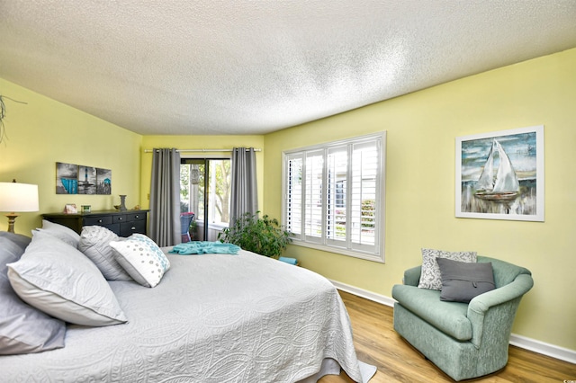 bedroom with wood-type flooring and a textured ceiling