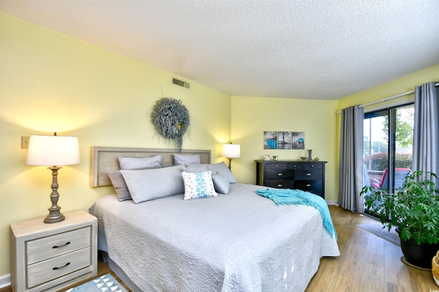 bedroom featuring light wood-type flooring and a textured ceiling