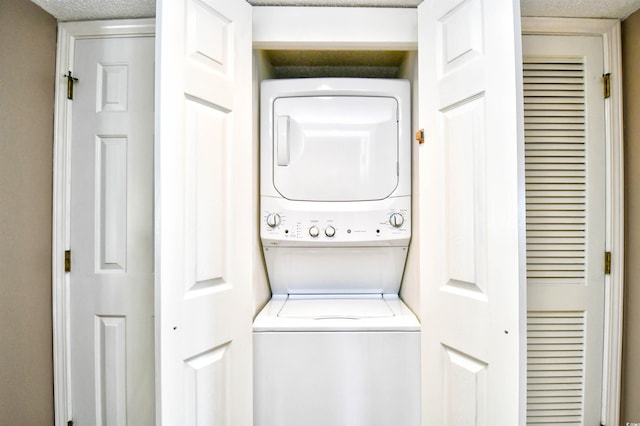 laundry area featuring stacked washing maching and dryer and a textured ceiling