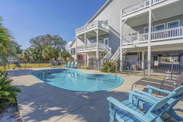 beach home featuring a front lawn, a balcony, and a carport