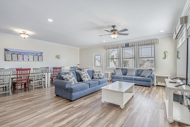 living room featuring ceiling fan, ornamental molding, and light hardwood / wood-style flooring