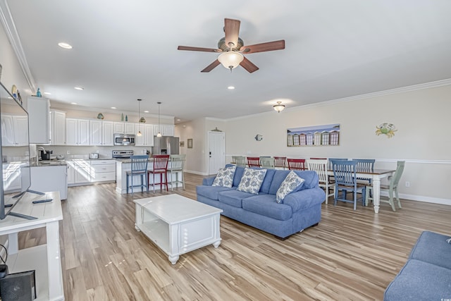 living room with ornamental molding, ceiling fan, and light hardwood / wood-style floors