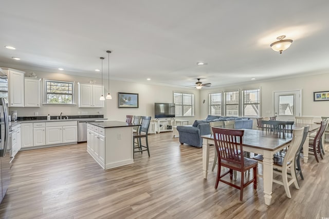 dining area with crown molding, ceiling fan, and light hardwood / wood-style floors