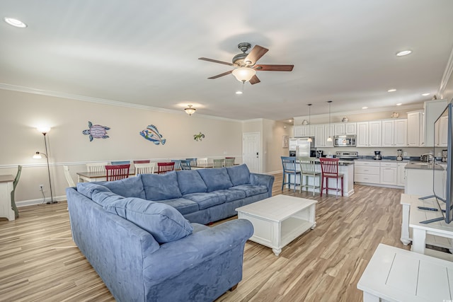 living room featuring crown molding, ceiling fan, and light wood-type flooring