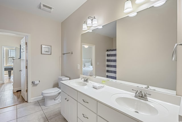 bathroom with tile patterned flooring, vanity, and toilet