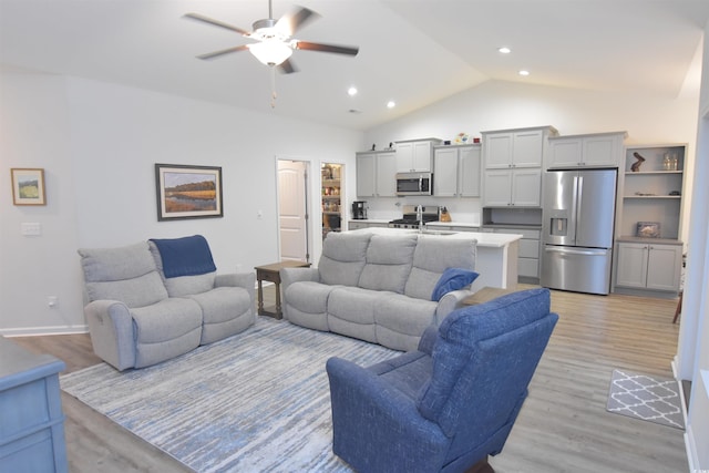 living room with ceiling fan, light hardwood / wood-style flooring, and lofted ceiling