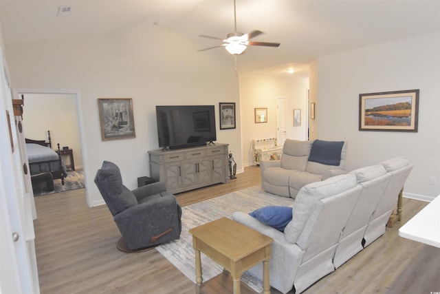 living room featuring light hardwood / wood-style flooring, ceiling fan, and vaulted ceiling