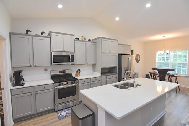 kitchen featuring sink, gray cabinetry, vaulted ceiling, and stainless steel appliances