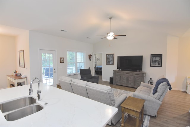 living room with wood-type flooring, sink, ceiling fan, and vaulted ceiling