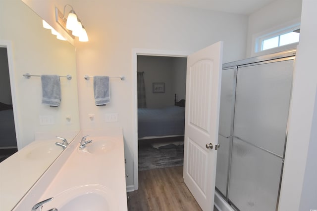 bathroom featuring hardwood / wood-style flooring, vanity, and an enclosed shower