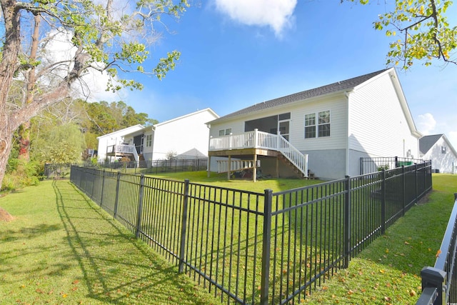 back of house featuring a lawn and a wooden deck