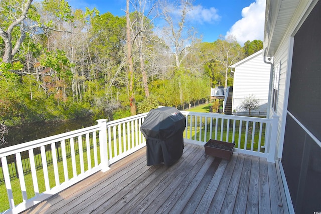 wooden deck with grilling area and a lawn