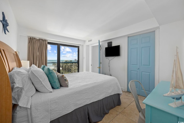 bedroom featuring light tile patterned flooring, access to exterior, and a closet