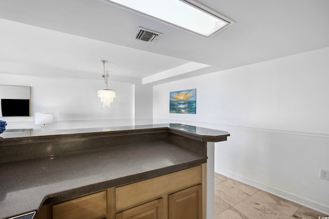 kitchen with a chandelier, light tile patterned floors, and pendant lighting