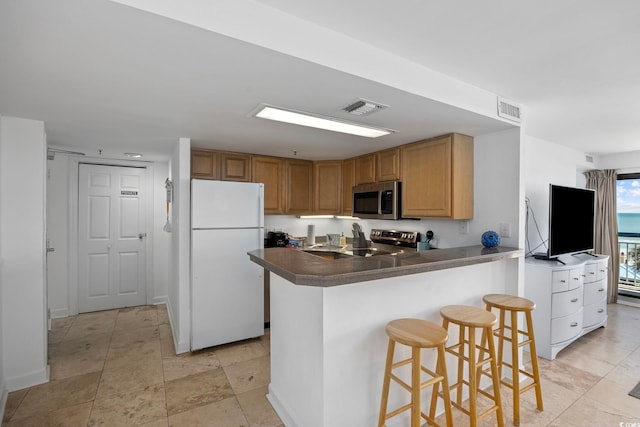 kitchen with kitchen peninsula, a kitchen bar, and stainless steel appliances