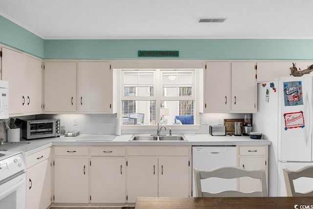 kitchen featuring white appliances, white cabinetry, and sink