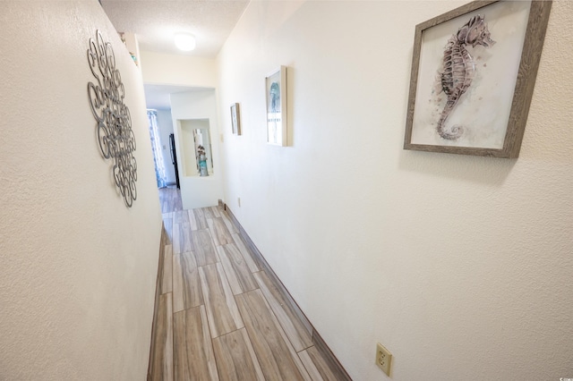 hall with a textured ceiling and hardwood / wood-style flooring