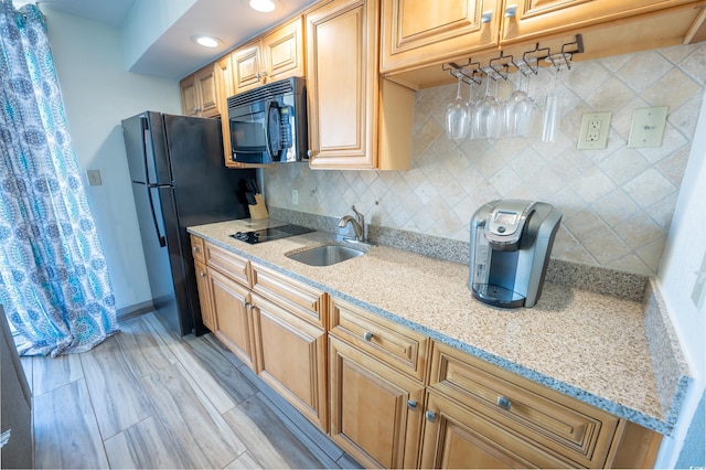 kitchen featuring decorative backsplash, black appliances, sink, and light stone counters