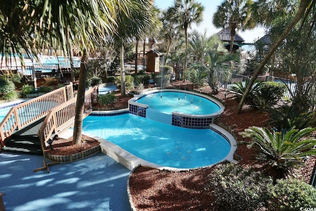 view of pool featuring an in ground hot tub