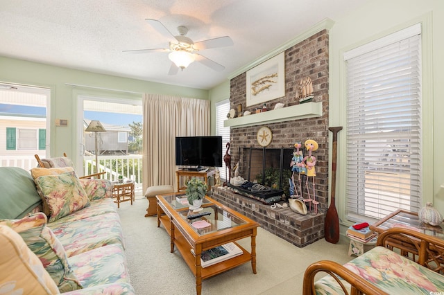 living room with a fireplace, a textured ceiling, ceiling fan, and carpet