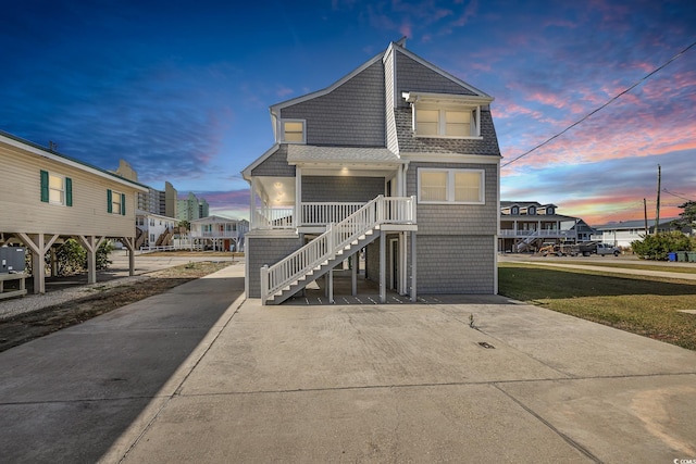 206 56th Ave N, North Myrtle Beach, SC 29582 - view of front of property featuring stairway, roof with shingles, and covered porch