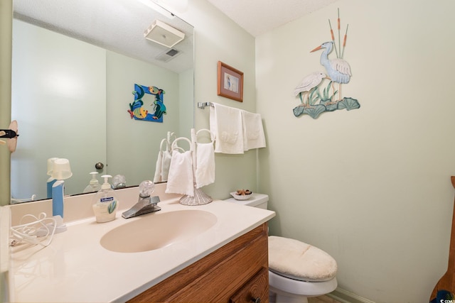 bathroom with vanity, a textured ceiling, and toilet