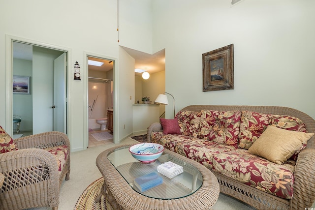 carpeted living room featuring a towering ceiling