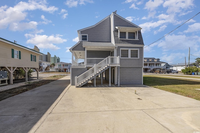 206 56th Ave N, North Myrtle Beach, SC 29582 - beach home with stairs, a shingled roof, a residential view, and a front yard
